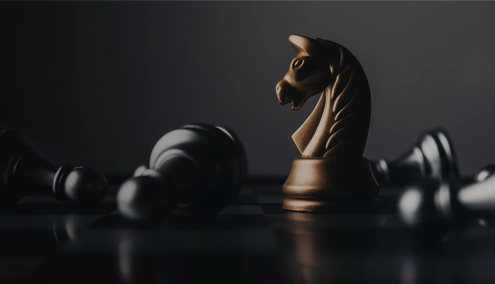 Cavalo dourado de xadrez em destaque sobre tabuleiro escuro, representando estratégia e tomada de decisão.